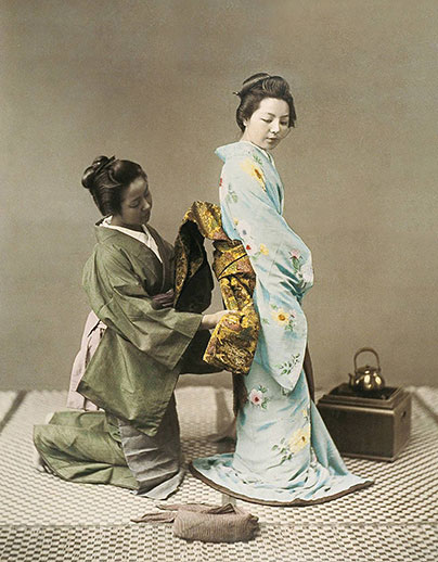 En geisha knyter en obi. Foto från 1890.